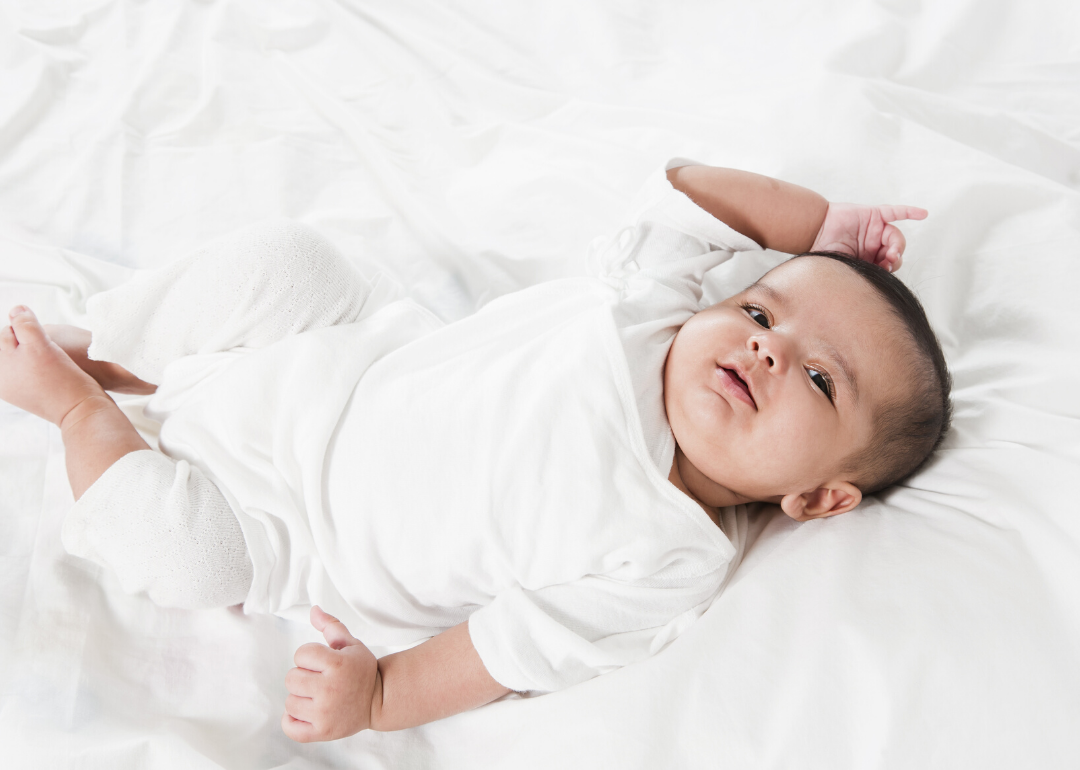 Baby girl laying in a bed after waking up.