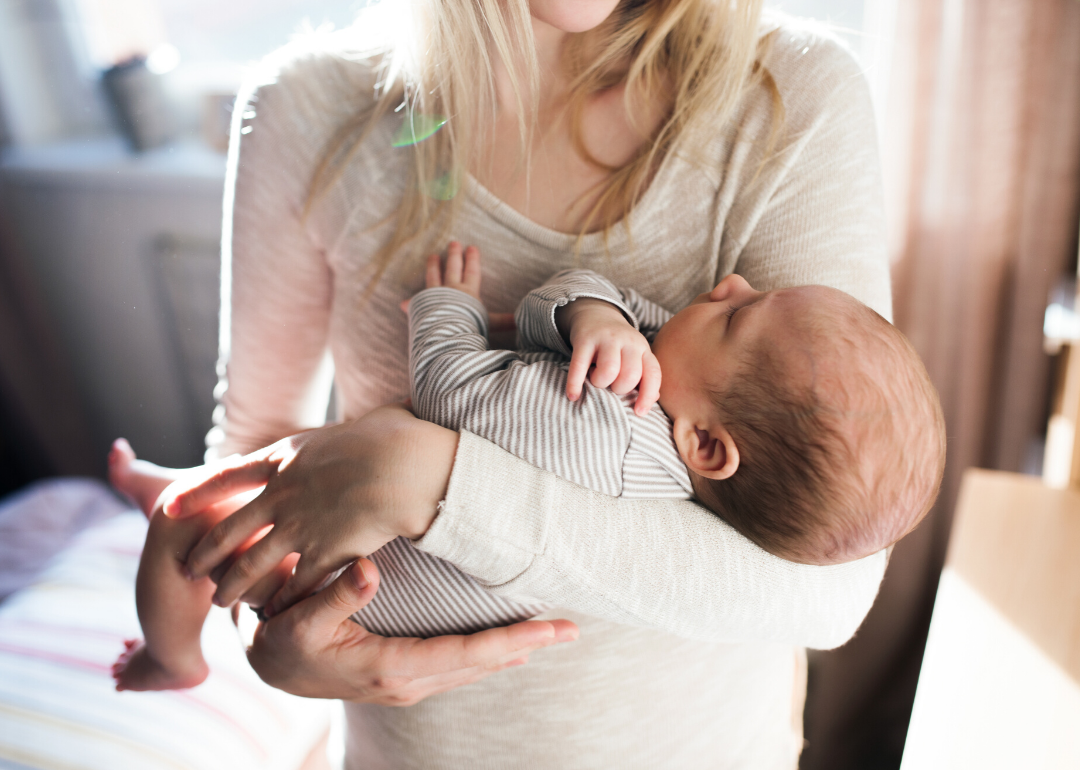 Unrecognizable young mother holding a baby in her arms.