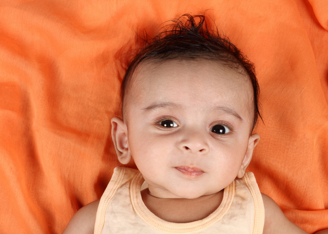 Baby boy on orange blanket.