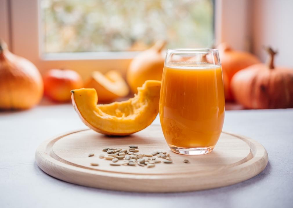 Pumpkin juice A glass of pumpkin juice with pumpkin seeds surrounding it.