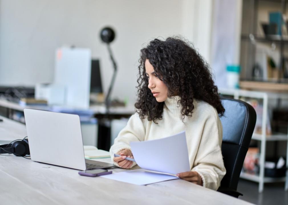 A worried woman reading on her computer.