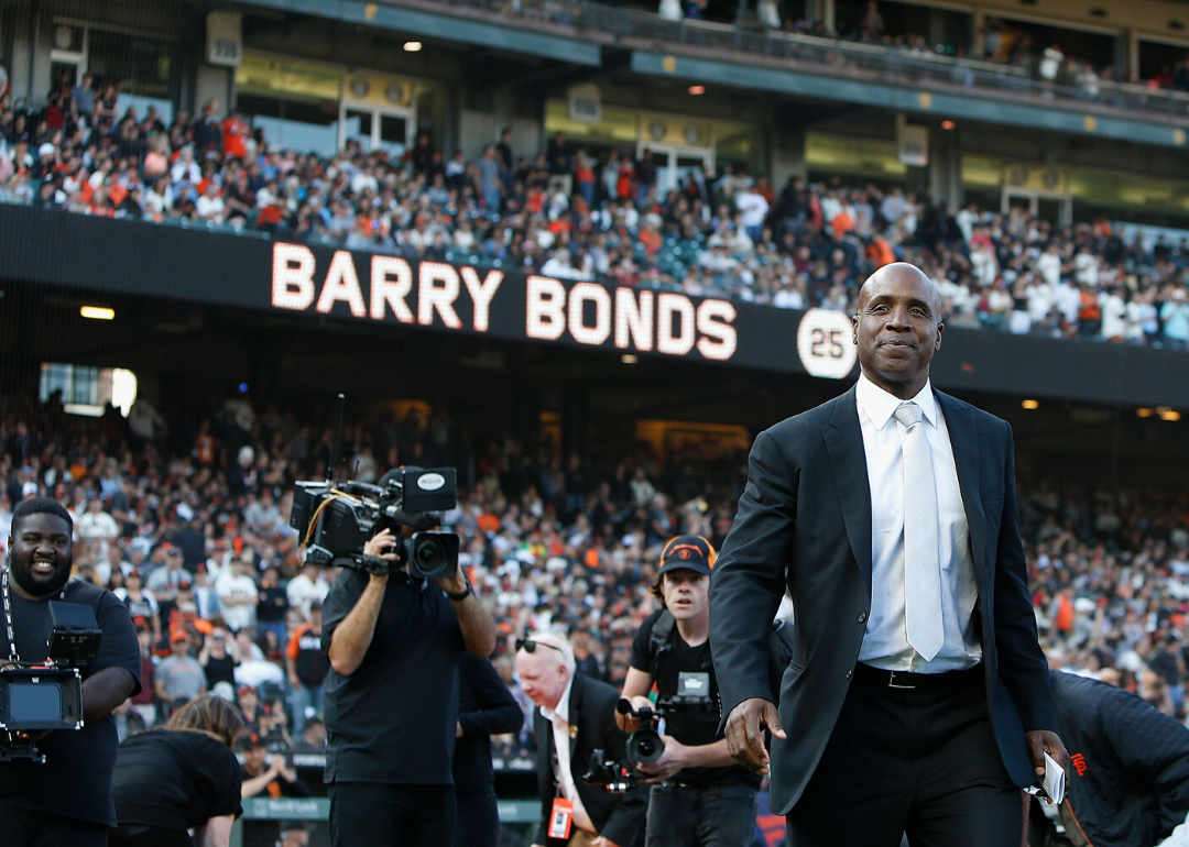 Barry Bonds in a suit walks on the field in San Francisco.