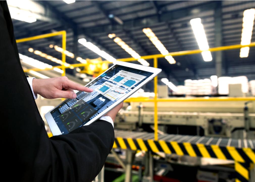 A manufacturer using a tablet to monitor data and systems