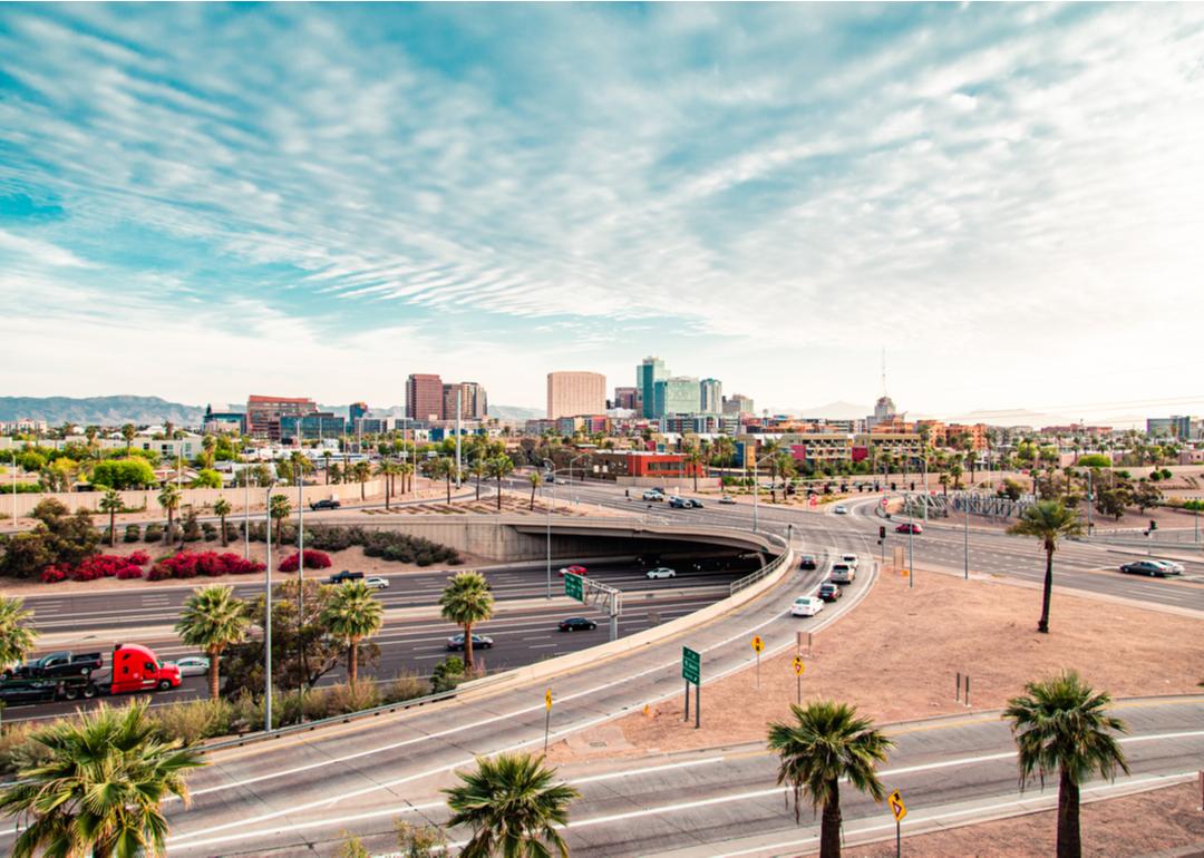 Cars driving on the highway towards downtown Phoenix, located in the background.