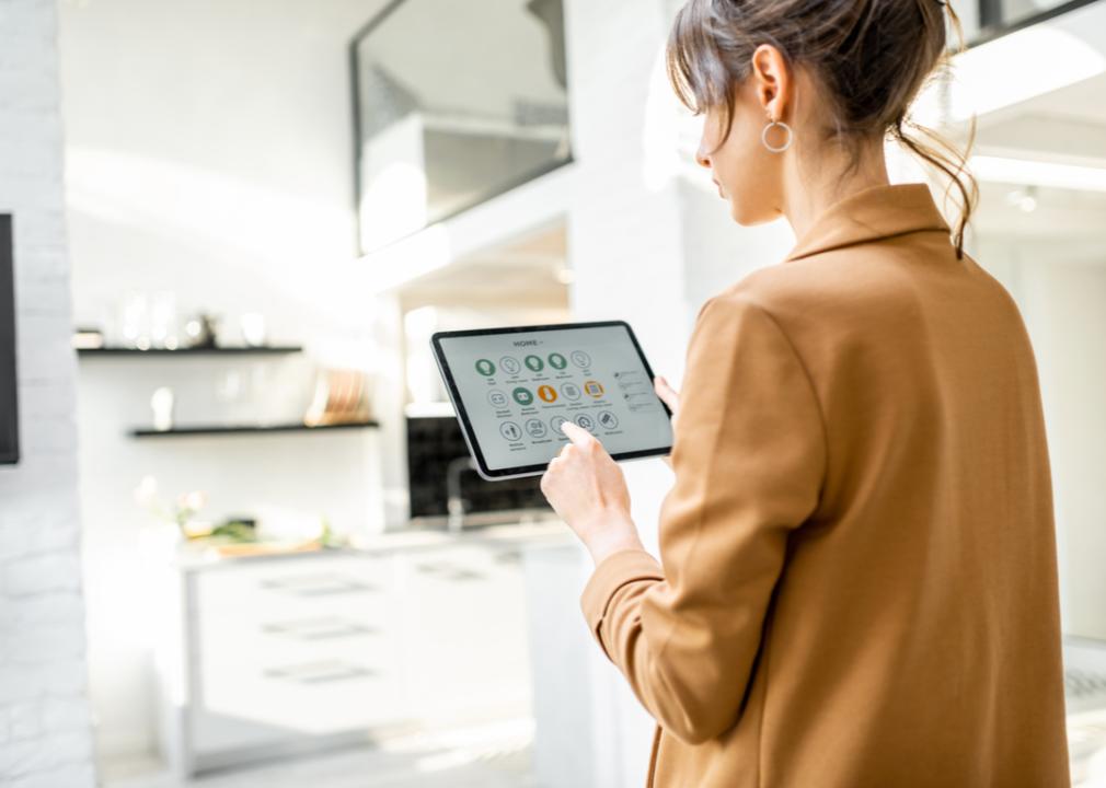 A woman viewing the status of her smart home devices using a digital tablet