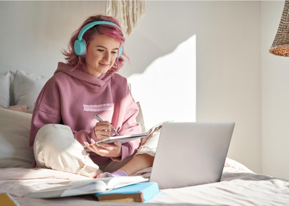 An online college student taking a class while in bed