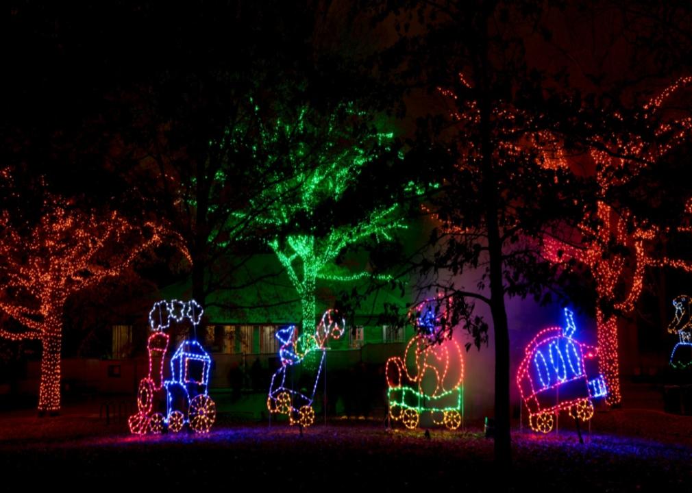 Holiday lights in the shape of a three-car train seen after dark.