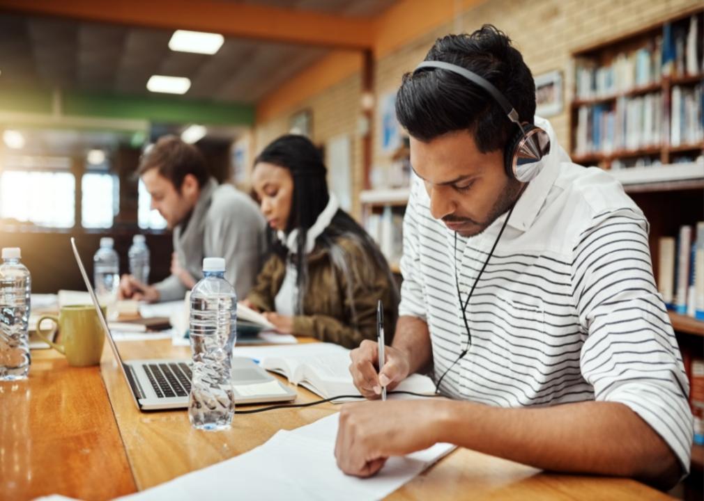 Students working at tables in a library.