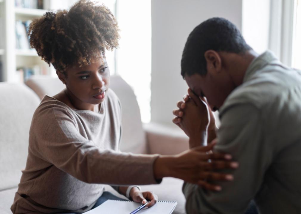 A woman consoling a man.