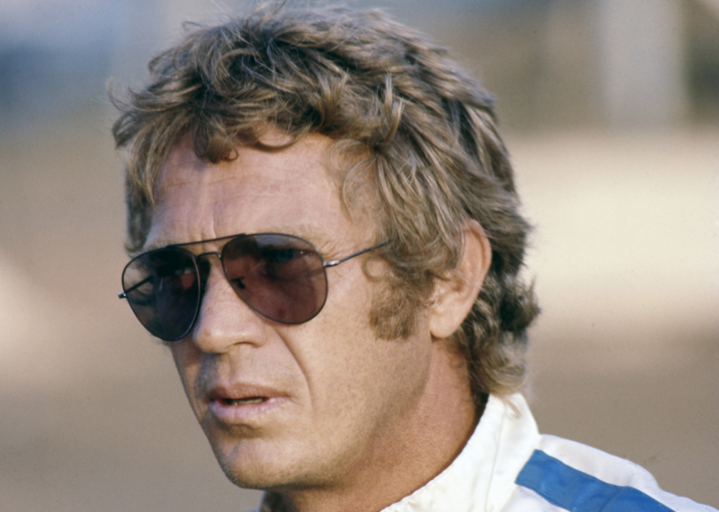 A close up of McQueen wearing aviator sunglasses on the set of Le Mans.