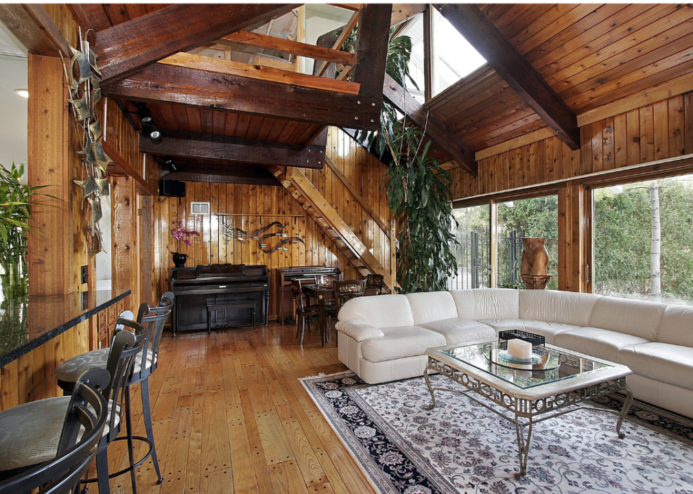 A wood-paneled family room with medium-colored slightly rustic wood covering the floors, walls, and ceiling. 