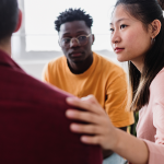 People in a group therapy session supporting each other.