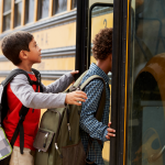 Elementary school kids climb aboard school bus