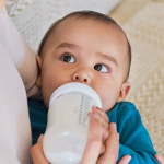 Mother feeding baby with bottle.