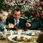 President Nixon eats with Premier Zhou En-lai and Zhang Chun-chiao at a farewell banquet.