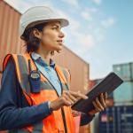 Supervisor in shipping container terminal holding tablet.