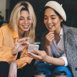 Two friends looking at phone together.