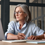 Serious mature woman looking at laptop.