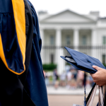 Students wear graduation gowns outside of the White House.