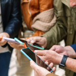 Close up view of senior group of people using smartphone.
