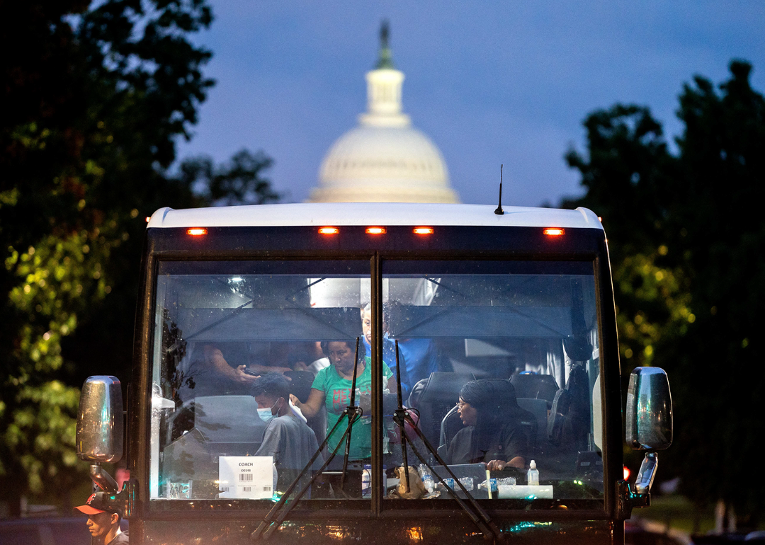 Migrants prepare to exit bus within view of the US Capitol building