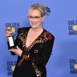 Meryl Streep smiling, holding her Golden Globe.