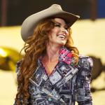 Shania Twain smiles on stage in a cowboy hat at the Calgary Stampede at Scotiabank Saddledome on July 10, 2014.
