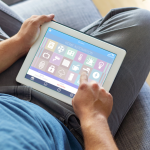 Man sitting on couch with smart home app on tablet