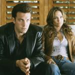 Ben Affleck and Jennifer Lopez sit on a couch as Larry Gigli and Ricki in 2003's "Gigli."