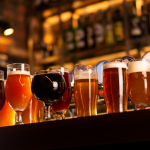 Selection of craft beers in different shaped glasses sitting on a bar.