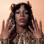 Donna Summer wears a sequined hooded outfit and shows off her nails in a 1976 portrait.