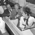 Enjoying the bobsled ride at Disneyland are the Shah of Iran and Empress Farah (in front of sled) and their host Walt Disney with a Disneyland hostess, Donna Jackson.