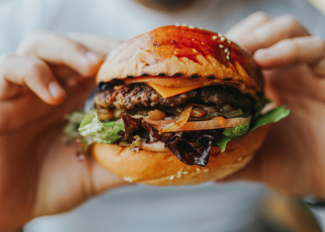 Closeup of hands holding a hamburger