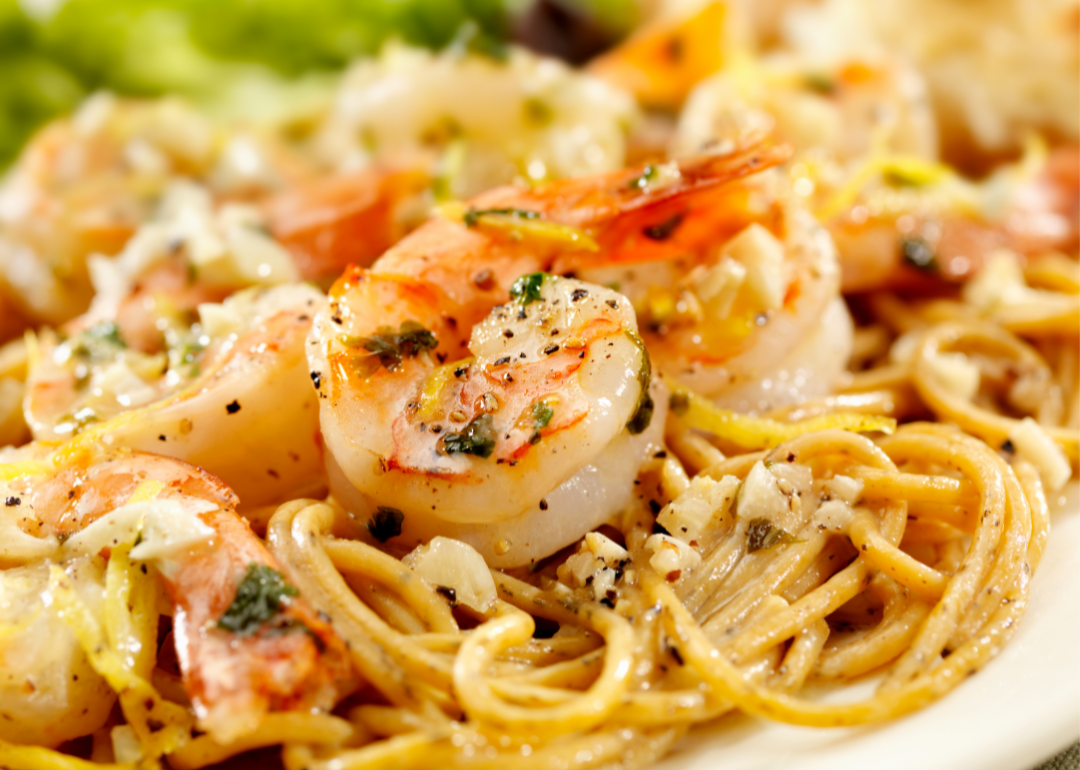 Closeup of parmasean-crusted shrimp scampi over pasta