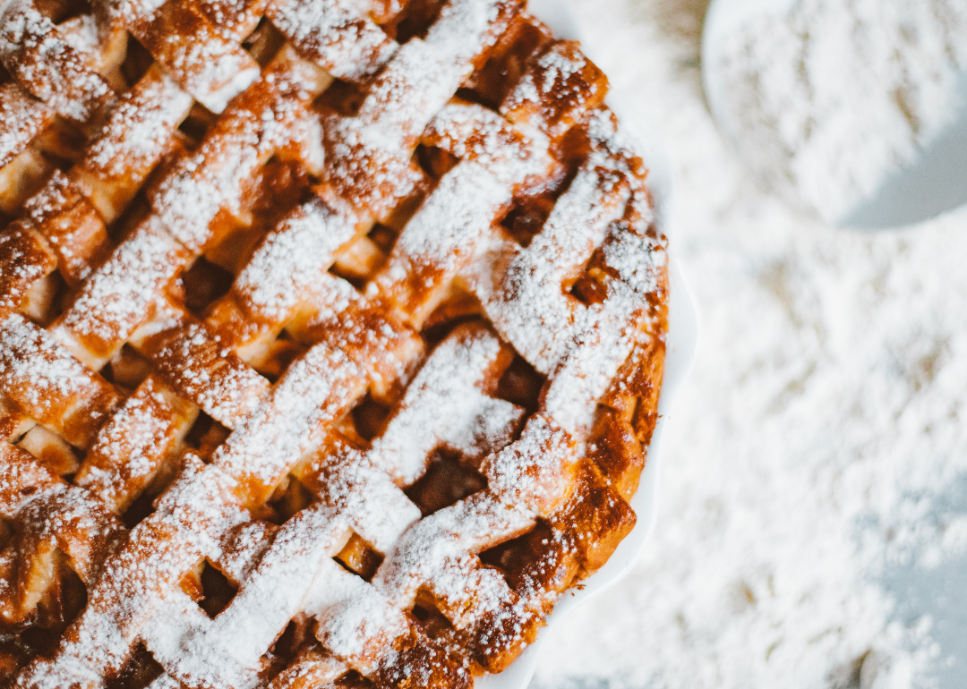 Close-up of a baked pie with a lattice design and powdered sugar
