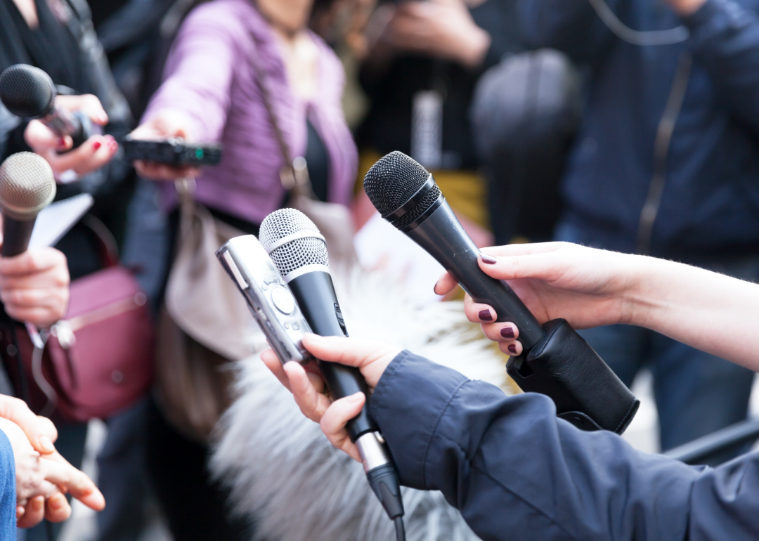 Closeup of reporters with microphone talking to a celebrity