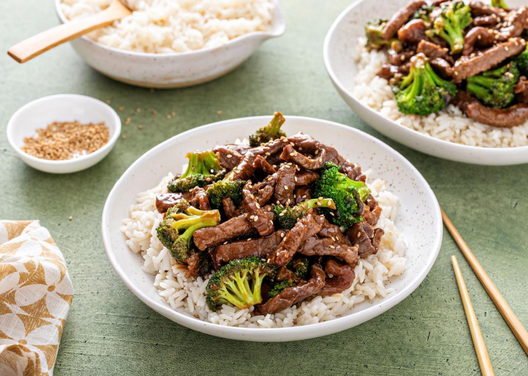 Beef and broccoli stir fry served over rice with sesame seeds