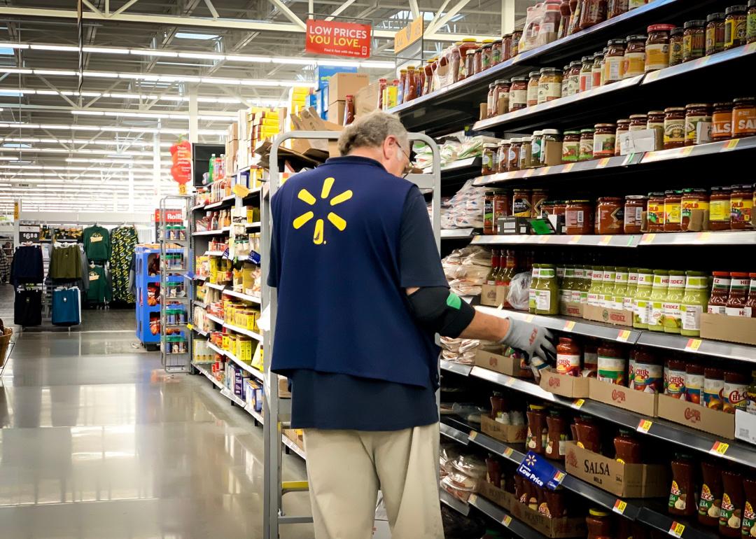 Walmart supermarket employee putting products on shelves.