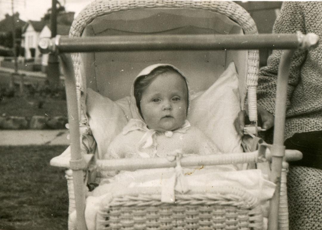 Vintage photo of baby girl in pram in the 1950s