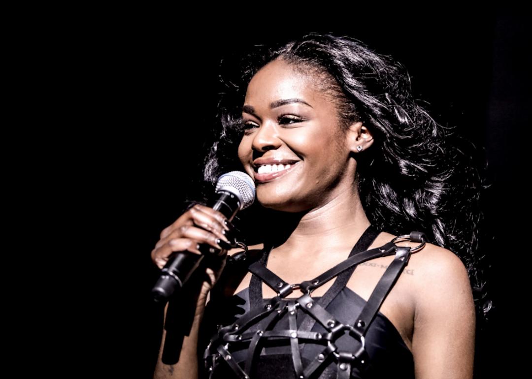 Azealia Banks performing with a microphone in her hand.