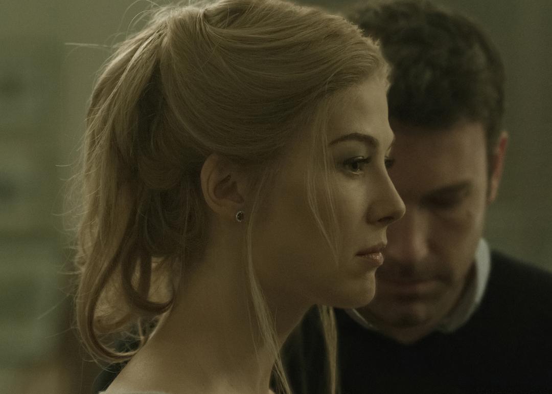 Rosamund Pike in the foreground with Ben Affleck in the background in a scene from the 2014 drama 'Gone Girl.'