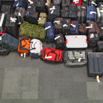 Lost luggage lined up on the floor in the airport.