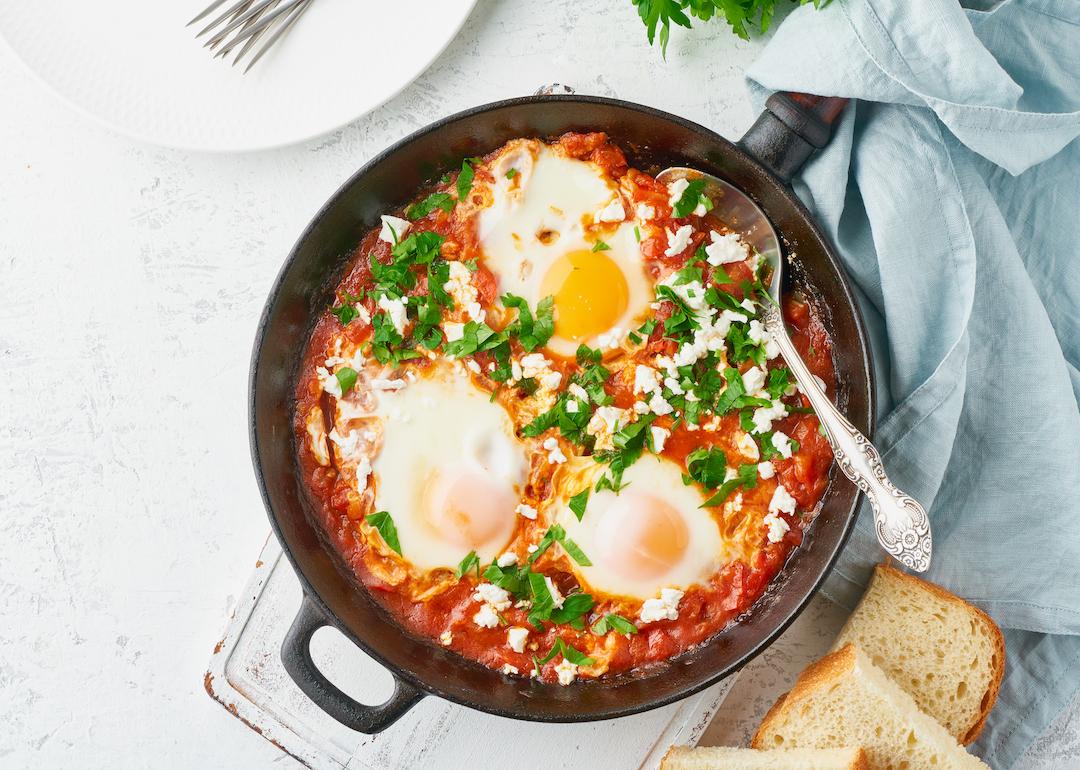 Shakshuka dish, made of eggs poached in sauce of tomatoes, olive oil, peppers, onion, and garlic.