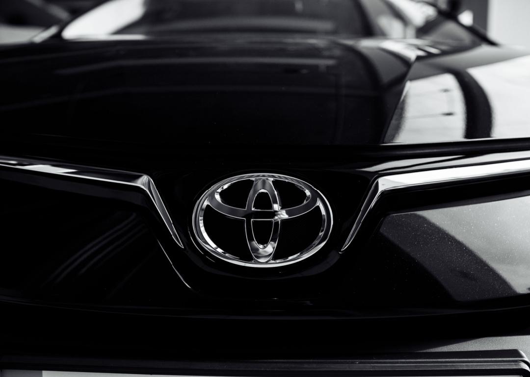 Close up of Toyota car logo on a black Toyota car.