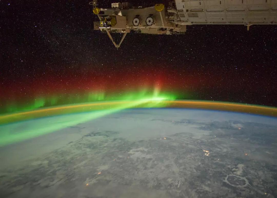 The snowy Quebec landscape illuminated by the stars, the moon, and the aurora.