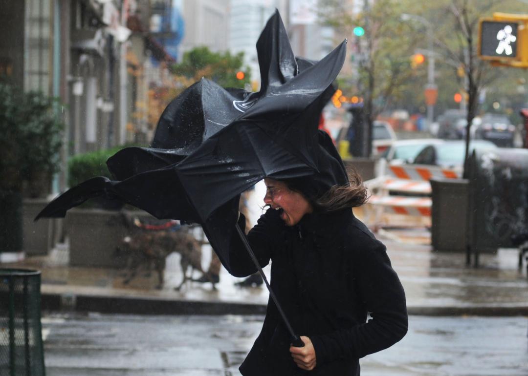 A person gets hit with a gust of wind in lower Manhattan just prior to Hurricane Sandy making landfall.
