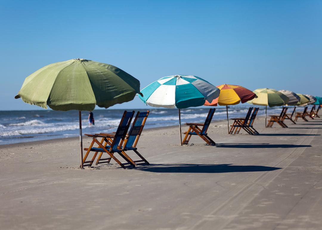 Sun chairs and sun umbrellas on a sandy beach in Galveston, Texas.