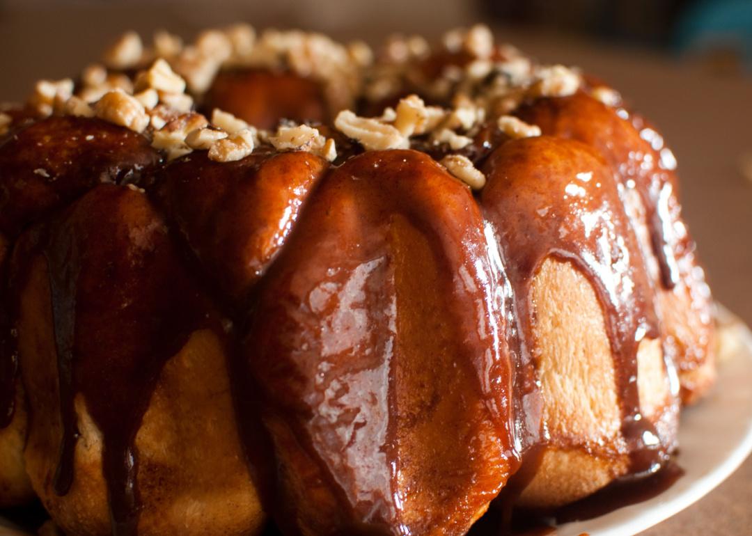 Sticky pull-apart monkey bread dripping with caramel and topped with nuts.