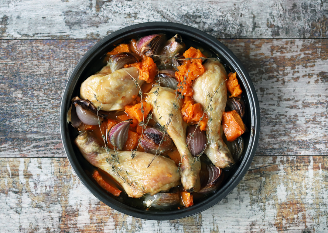 Chicken and veggies in a slow cooker photographed from above.