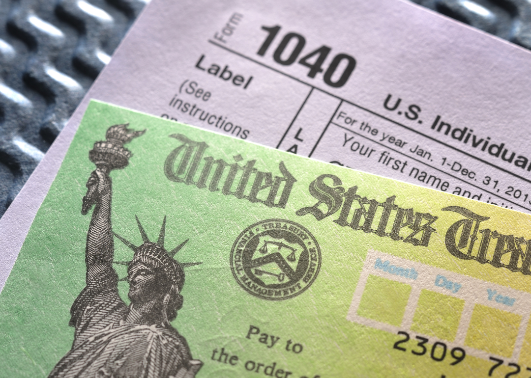 A tax refund check rests atop a 1040 tax form.